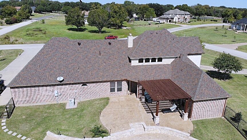 Stone home photographed head-on from the air, every roof plane visible